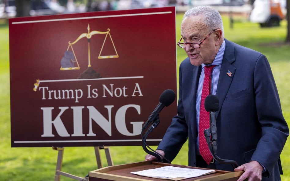 Lider senackiej mniejszości Chuck Schumer obok planszy z napisem „Trump nie jest królem”
