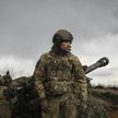 Ukraiński żołnierz stoi przed haubicą 105 mm w pobliżu Bachmutu