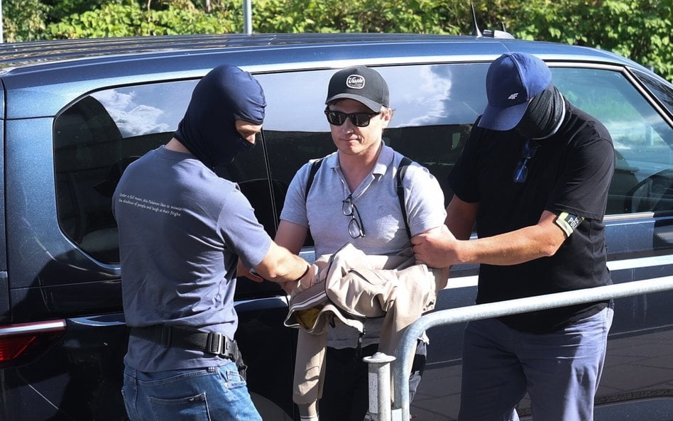 Inwestor giełdowy Rafał Zaorski (C) doprowadzany do delegatury Prokuratury Krajowej w Katowicach