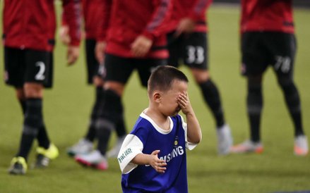 Chłopiec płaczący po pozowaniu do zdjęcia z graczami Realu Madryt przed meczem AC Milan i Realu Madr