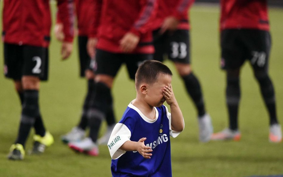 Chłopiec płaczący po pozowaniu do zdjęcia z graczami Realu Madryt przed meczem AC Milan i Realu Madr