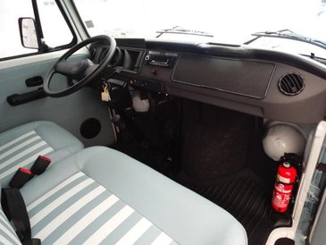 Klasycznie zaaranżowana kabina ma biało-niebieską tapicerką i stylowe zasłonki w oknach.