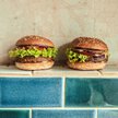 Z lewej strony wegański burger, z prawej burger wołowy sieci Bobby Burger