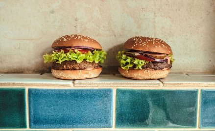 Z lewej strony wegański burger, z prawej burger wołowy sieci Bobby Burger