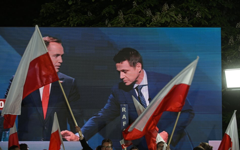 Rafał Trzaskowski kładzie kopertę na pulpicie Karola Nawrockiego