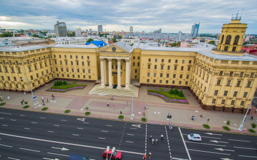Potężna fasada gmachu KGB. Za nią znajduje się ponura Amerykanka