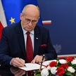 Minister spraw zagranicznych Zbigniew Rau podpisuje notę dyplomatyczną