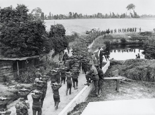 Żołnierze Wehrmachtu z rękami nad głowami idą do alianckiej niewoli po poddaniu cytadeli, fortyfikac