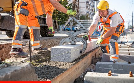Robotnicy precyzyjnie umieszczają bardzo ciężki bloki granitu