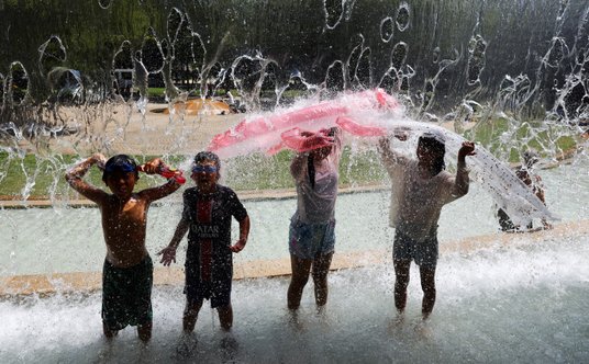 Dzieci bawią się w fontannie w parku w centrum Tokio