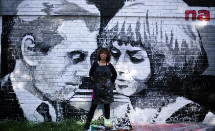 Olga Wolniak na tle muralu z Kaliną Jędrusik i Andrzejem Łapickim