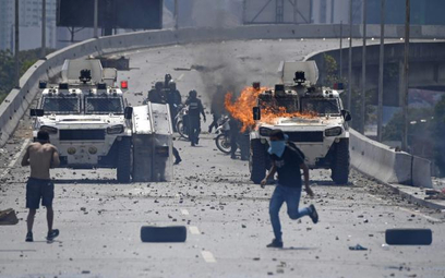 Uzbrojeni w kamienie zwolennicy Guaidó kontra transportery siły Maduro, 30 kwietnia 2019 r.