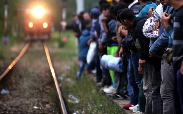 Imigranci z Azji czekają w Macedonii na pociąg, który przybliży ich do Węgier