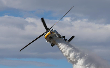 Wielozadaniowy śmigłowiec pożarniczy Sikorsky S-70i Firehawk podczas zrzutu środka gaśniczego. Fot./