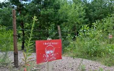 Znak z napisem "Uwaga miny" na zamkniętym punkcie kontrolnym Sławutycz na granicy ukraińsko-białorus