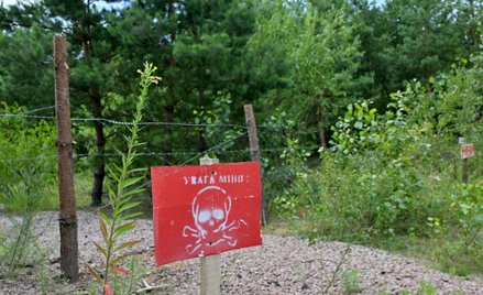 Znak z napisem "Uwaga miny" na zamkniętym punkcie kontrolnym Sławutycz na granicy ukraińsko-białorus