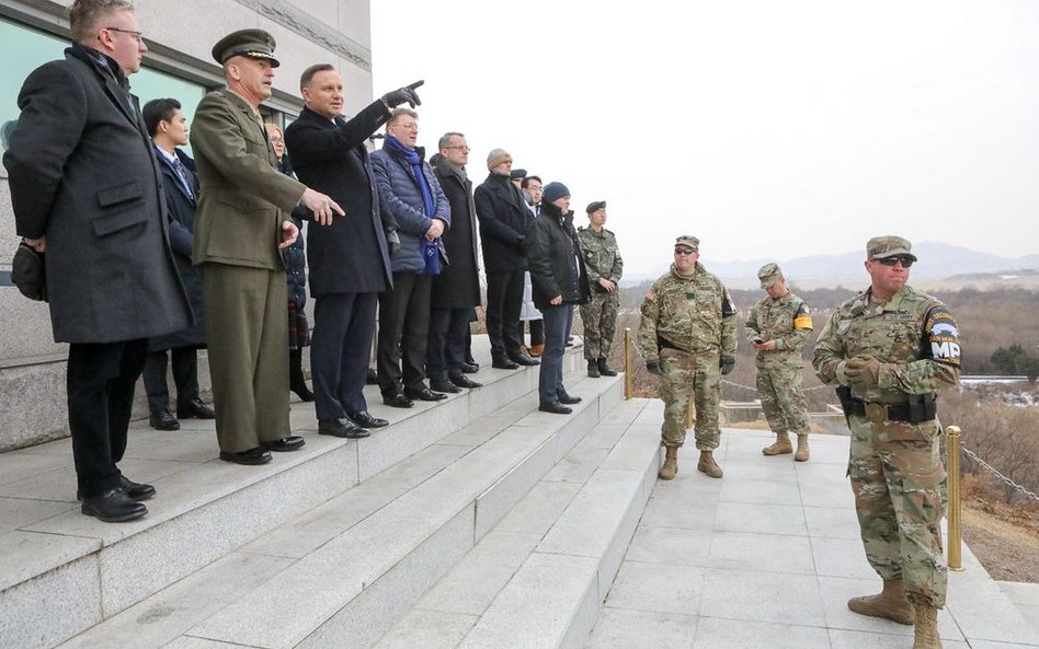 Prezydent Andrzej Duda w strefie zdemilitaryzowanej. Obok strażnik z lornetką