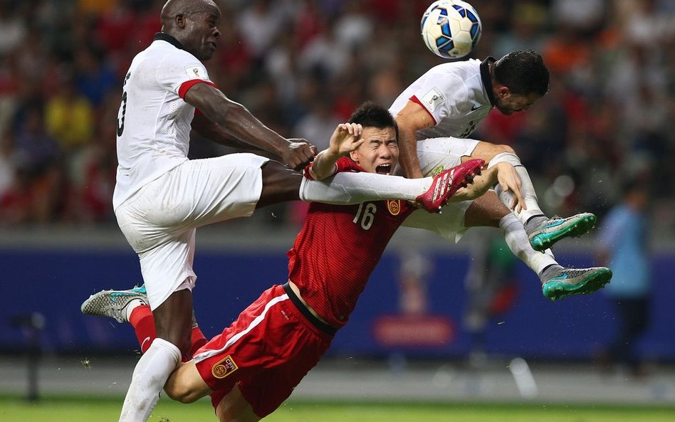 Reprezentant Chin Sun Ke walczy o piłkę z Jeanem Jacquesem Kilamą z Hong Kongu w trakcie eliminacji 