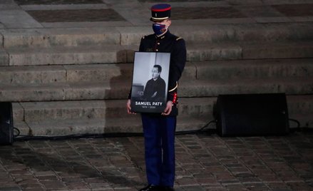 Członek Gwardii Republikańskiej trzyma portret zamordowanego Samuela Paty'ego podczas uroczystości p