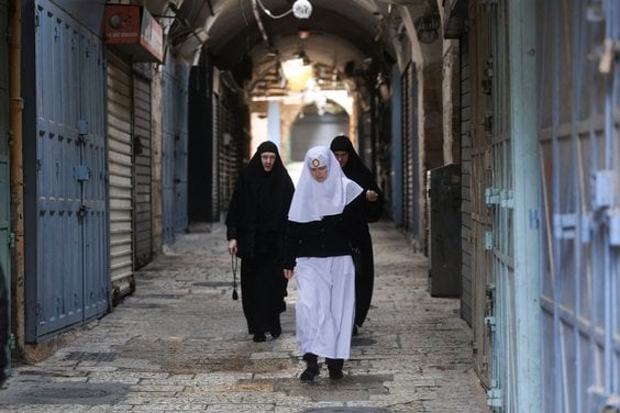 Chrześcijanie w pobliżu Bazyliki Grobu Świętego w Jerozolimie, fotografia wykonana w Niedzielę Palmo