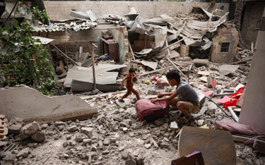 Palestyńskie dzieci na gruzach domu zniszczonego w izraelskim nalocie na Rafah