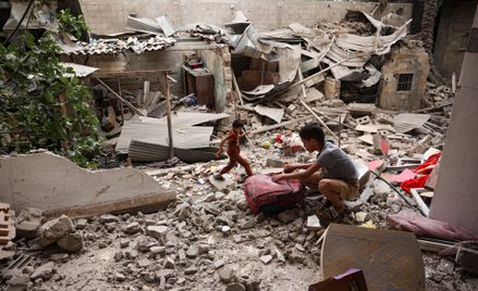 Palestyńskie dzieci na gruzach domu zniszczonego w izraelskim nalocie na Rafah
