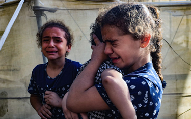 Dzieci podczas pogrzebu rodziny zabitej w izraelskim bombardowaniu Rafah w południowej Strefie Gazy