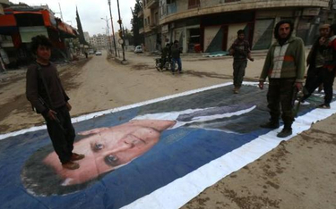 Dżihadyści depczą portret Baszara Asada. Idlib na północnym zachodzie Syrii.
