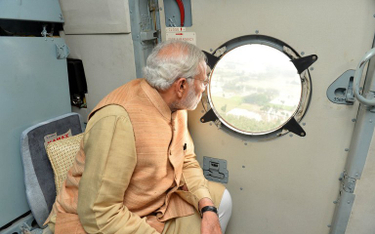 Oryginalne zdjęcie premiera Narendry Modiego patrzącego na zalane tereny z okna helikoptera