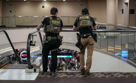 Agenci organów ścigania czekają w kolejce do kontroli bezpieczeństwa na punkcie kontrolnym Administr