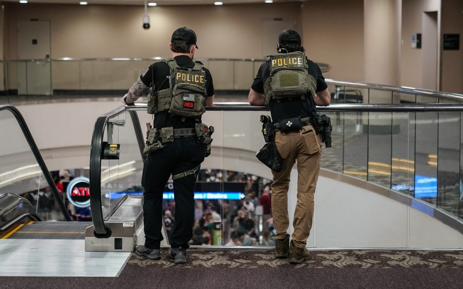 Agenci organów ścigania czekają w kolejce do kontroli bezpieczeństwa na punkcie kontrolnym Administr