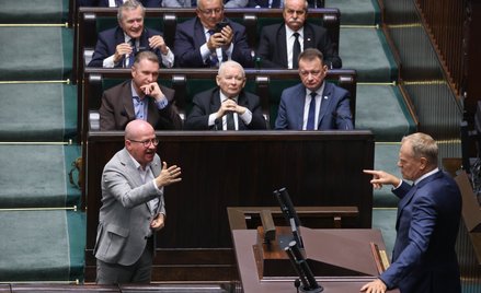 Premier Donald Tusk przemawia na sali obrad Sejmu. Przed mównicą poseł PiS Bartłomiej Wróblewski, w 