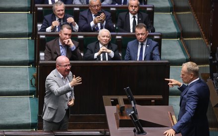 Premier Donald Tusk przemawia na sali obrad Sejmu. Przed mównicą poseł PiS Bartłomiej Wróblewski, w 