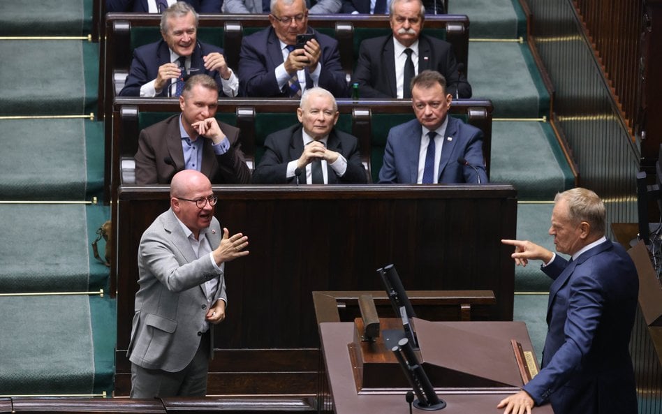 Premier Donald Tusk przemawia na sali obrad Sejmu. Przed mównicą poseł PiS Bartłomiej Wróblewski, w 
