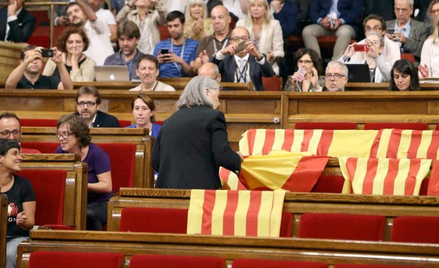 Deputowana „Podemos” Angels Martinez zabiera flagi Hiszpanii pozostawione przez deputowanych przeciw