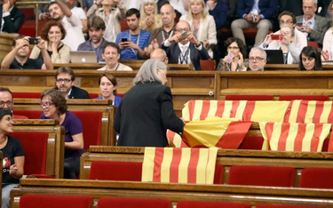 Deputowana „Podemos” Angels Martinez zabiera flagi Hiszpanii pozostawione przez deputowanych przeciw