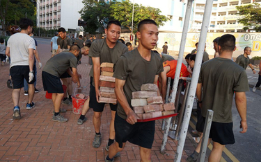 Żołnierze z garnizonu Chińskiej Armii Ludowo-Wyzwoleńczej porządkują ulice Hongkongu po zamieszkach
