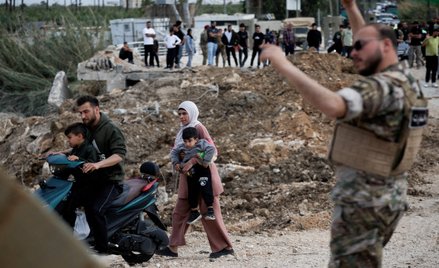 Przesiedleni mieszkańcy wracają do swoich domów, przekraczając most łączący południowy Liban z reszt