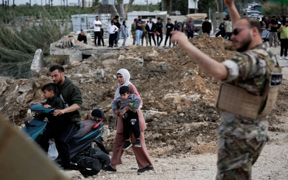 Przesiedleni mieszkańcy wracają do swoich domów, przekraczając most łączący południowy Liban z reszt