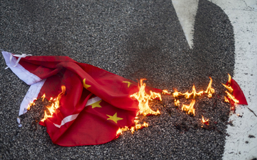 Płonąca chińska flaga po demonstracji w Hongkongu