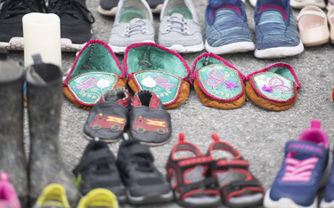 Dziecięce buty, ustawione jako symbol ofiar sieci dawnych szkół stacjonarnych, przed kościołem pw. ś