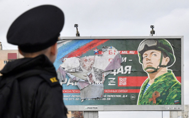 Rosyjski kadet przed plakatyem zachęcającym do wstąpienia do armii