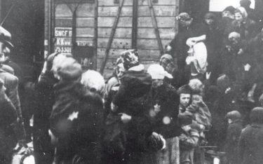 Żydowskie kobiety i dzieci wysiadają z wagonów towarowych na rampie niemieckiego obozu śmierci Ausch