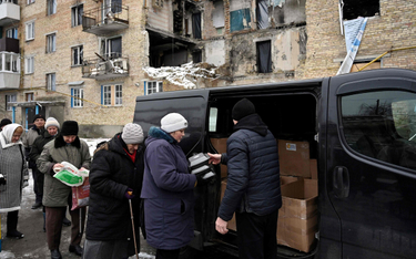 Mieszkańcy Horenki (niedaleko Buczy), zniszczonej w wyniku rosyjskich ataków, stoją w kolejce po pom