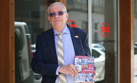 Prof. Wojciech Roszkowski ze swoim podręcznikiem przed siedzibą PAP