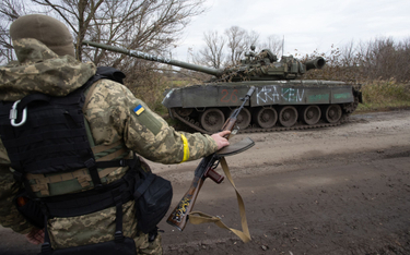 Ukraiński żołnierz obok uszkodzonego rosyjskiego czołgu, obwód charkowski, fot. z 23 października