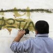 Czy Grecja wyjdzie z kryzysu? Na zdjęciu: zamazywanie słowa „pożar”, które ktoś namalował na logo Ba