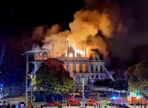To zdjęcie przedstawia pożar płonący i niszczący ratusz po tym, jak grupa osób wdarła się do budynku