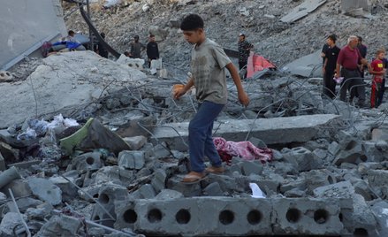 Młody Palestyńczyk na gruzach budynku, w którym Palestyńczycy szukali schronienia