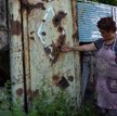 70-letnia Armenka wskazuje na bramę dziedzińca w wiosce Ajgepar w prowincji Tawusz, uszkodzoną w wyn
